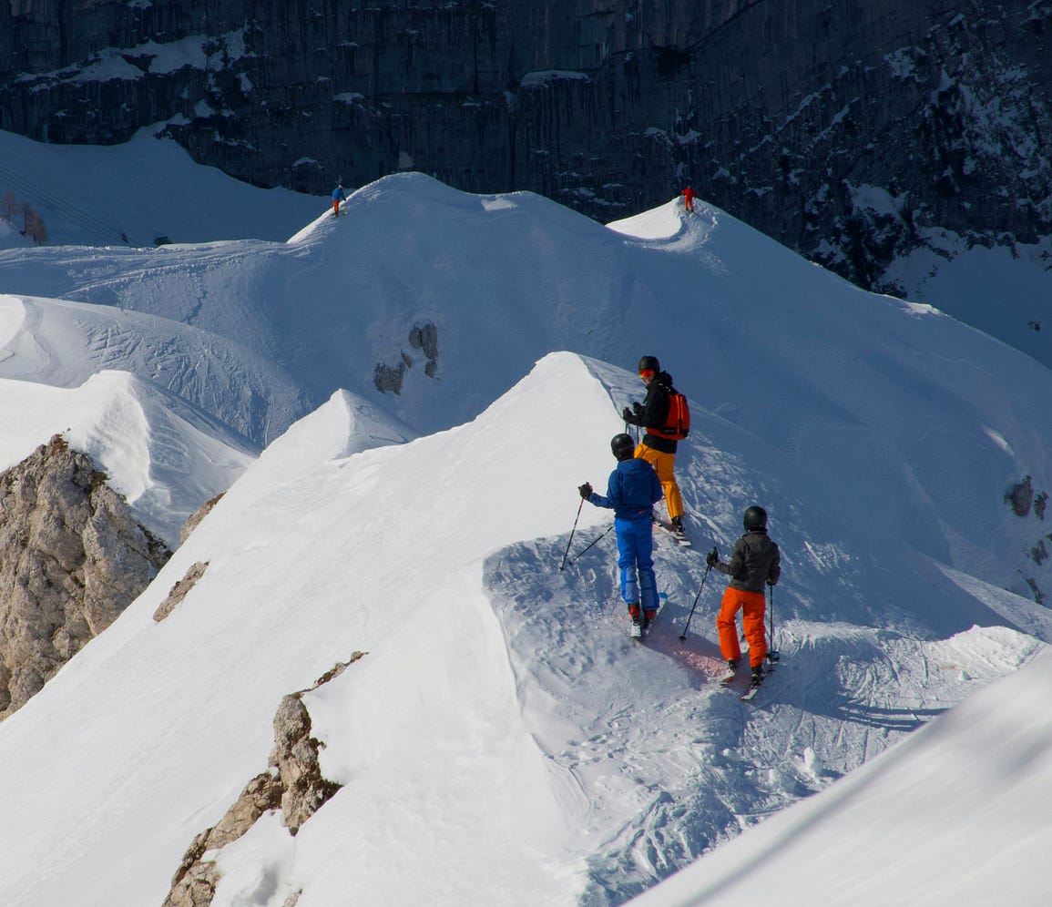 3 men walking together on a snowy mountain